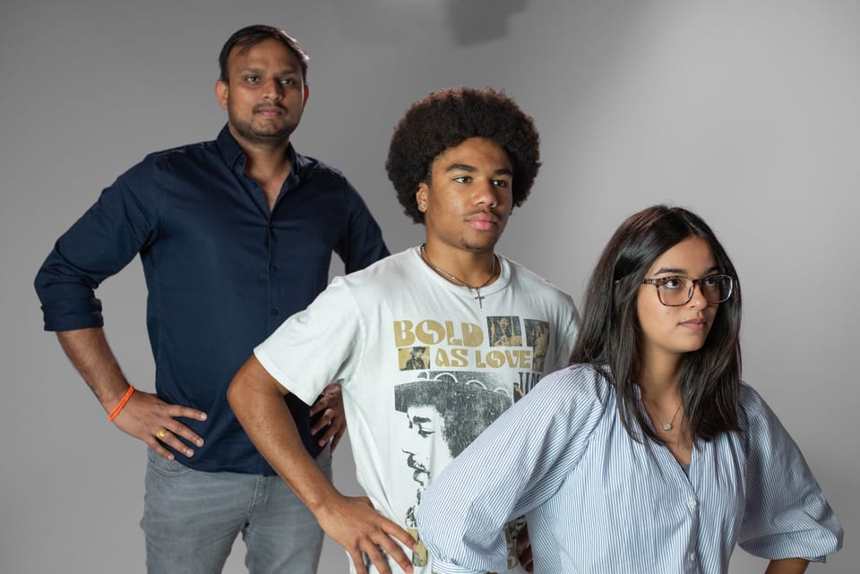 Three coworkers striking a team pose, hands on hips.